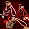 A golden diamond-encrusted flower-shaped keychain with a beige woven leather rope handle ring Specification image